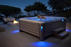 A couple enjoying an evening soak in a Grandee NXT spa, highlighting the luxurious spa experience.