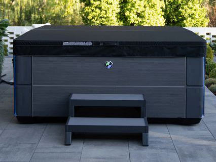 Hot Spring Spa's Aria hot tub is shown in charcoal color with a black Weather Pro™  Cover.