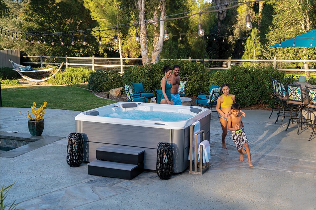 A beautiful backyard setup with a Hot Spring spa, highlighting the cost considerations for a hot tub purchase.