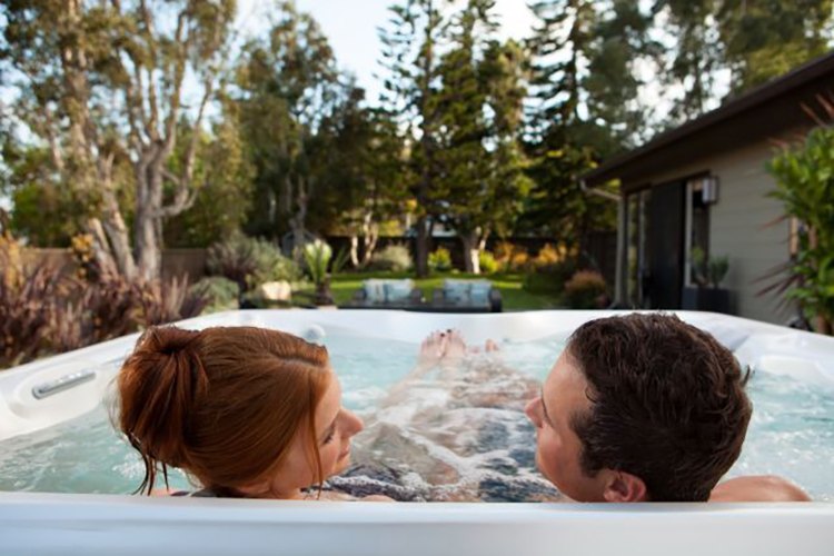 A couple relaxes in a Hot Spring Spa hot tub
