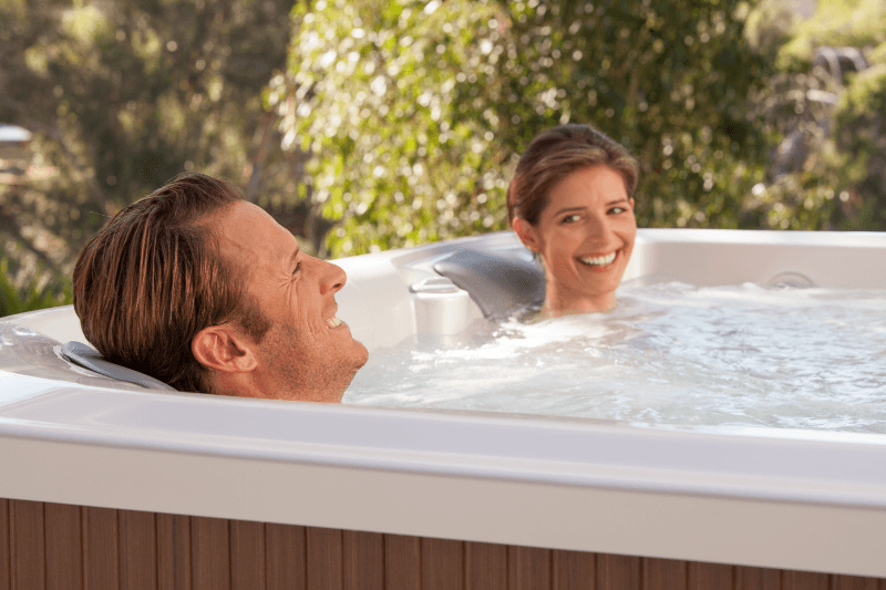 A happy couple relaxes and enjoys a bubbly soak in a luxurious hot tub.